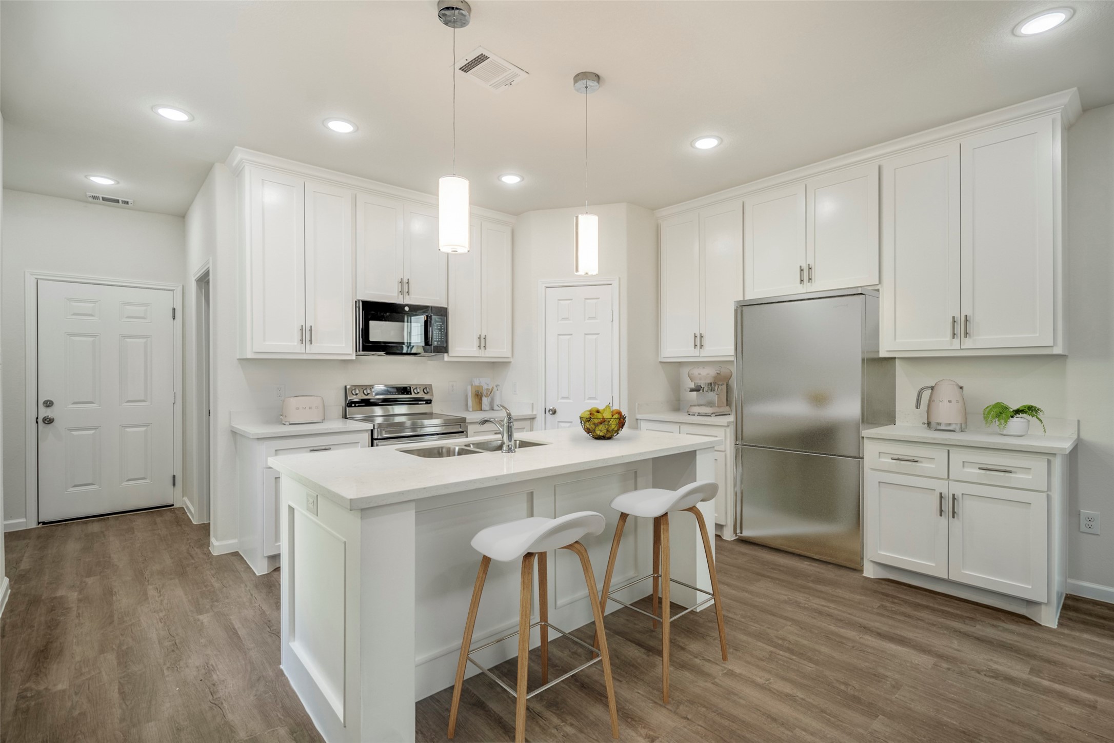 6513 Goldspier Street Houston, TX 77091 - Photo 3 of 31 a kitchen with white cabinets stainless steel appliances and wooden floor