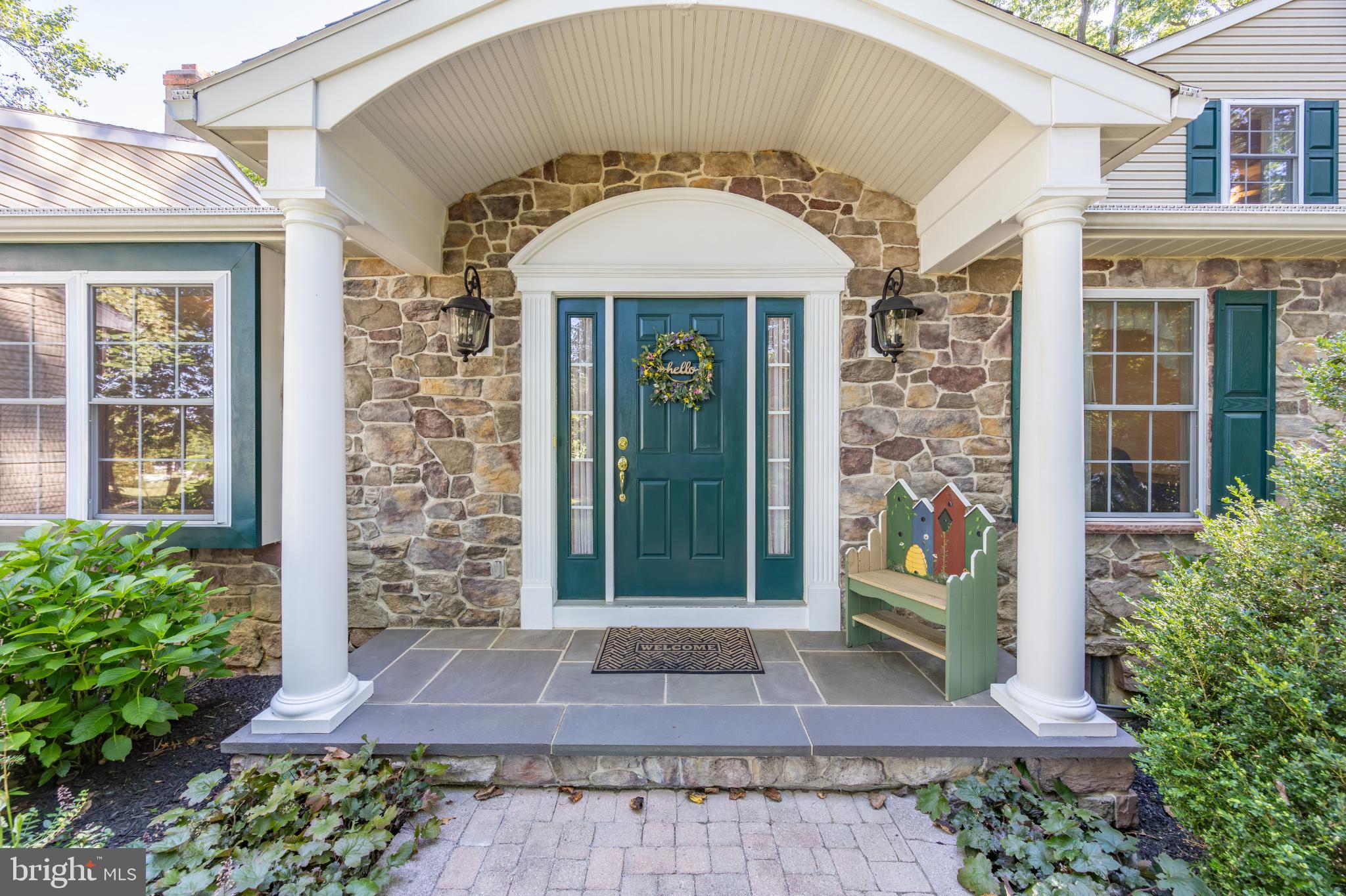 116 Cambridge Road Coatesville, PA 19320 - Photo 5 of 48 Charming stone entrance with vibrant greenery.