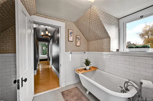 a bathroom with a tub sink and mirror