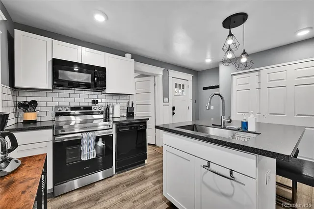 a kitchen with stainless steel appliances granite countertop a sink a stove and a microwave