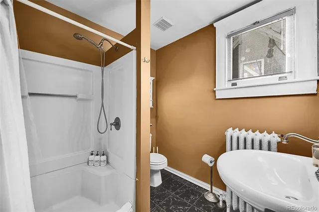 a bathroom with a toilet and a shower