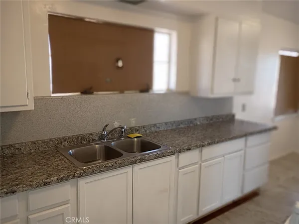 a kitchen with granite countertop a sink and cabinets