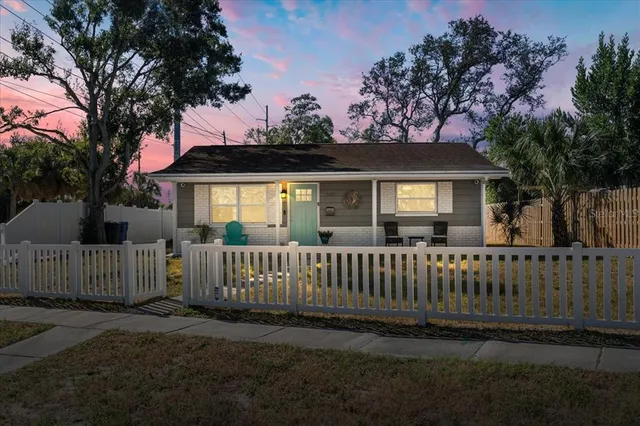 a view of a house with a small yard and wooden fence