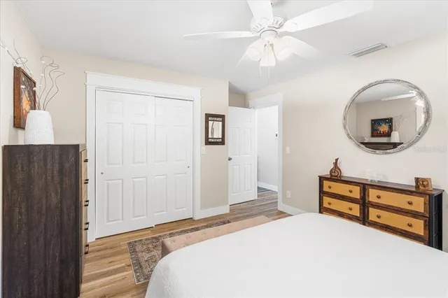 a bedroom with a bed and a dresser with mirror