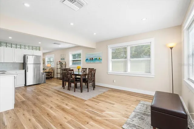 a living room with furniture and a dining table with kitchen view