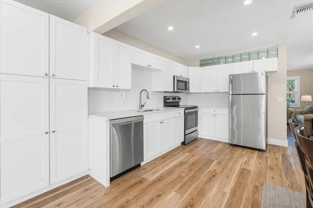 a kitchen with white cabinets and white appliances