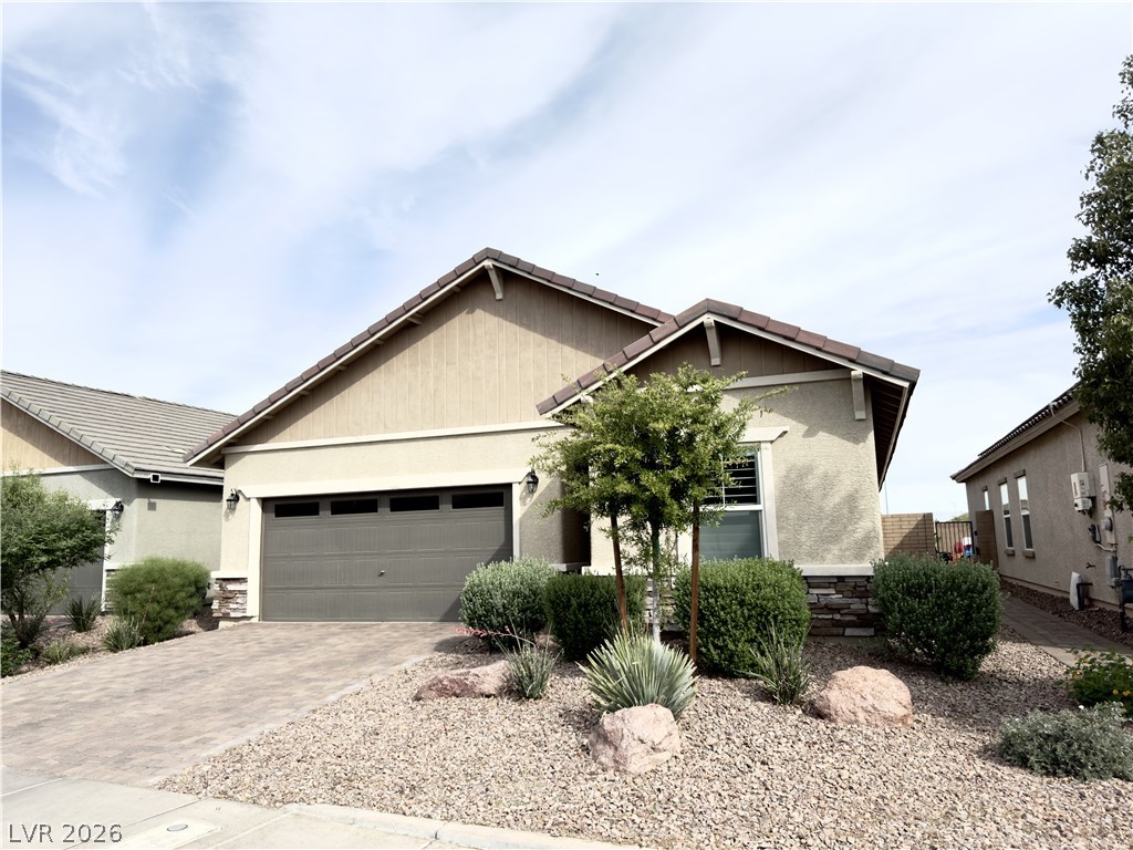 78 Summer Rhapsody Avenue Henderson, NV 89015 - Photo 2 of 31 View of front of home with stone siding, driveway, a garage, and stucco siding
