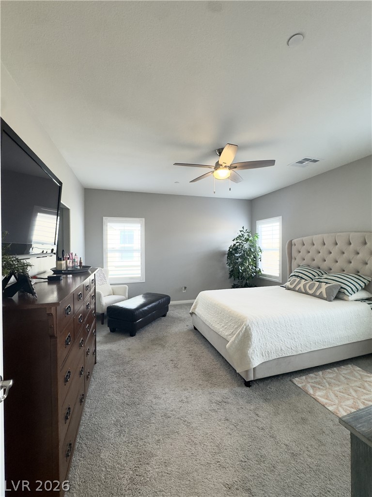 78 Summer Rhapsody Avenue Henderson, NV 89015 - Photo 20 of 31 Bedroom featuring multiple windows, light colored carpet, and a ceiling fan