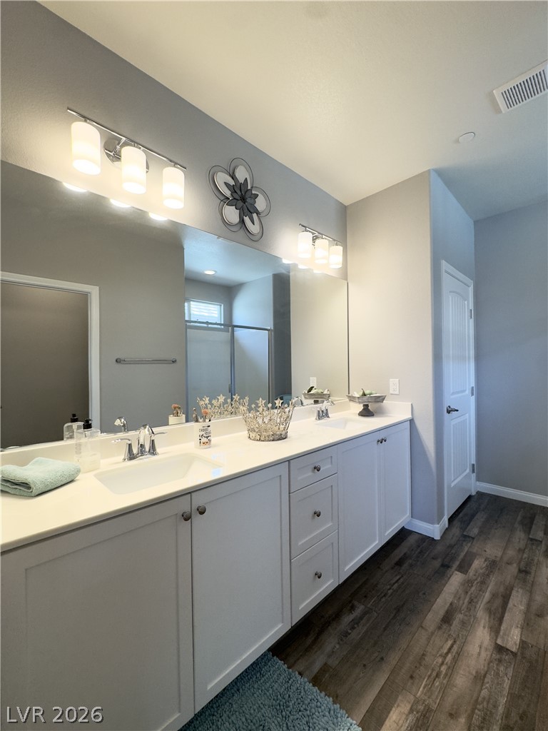 78 Summer Rhapsody Avenue Henderson, NV 89015 - Photo 27 of 31 Full bathroom with double vanity, dark wood finished floors, and a shower stall