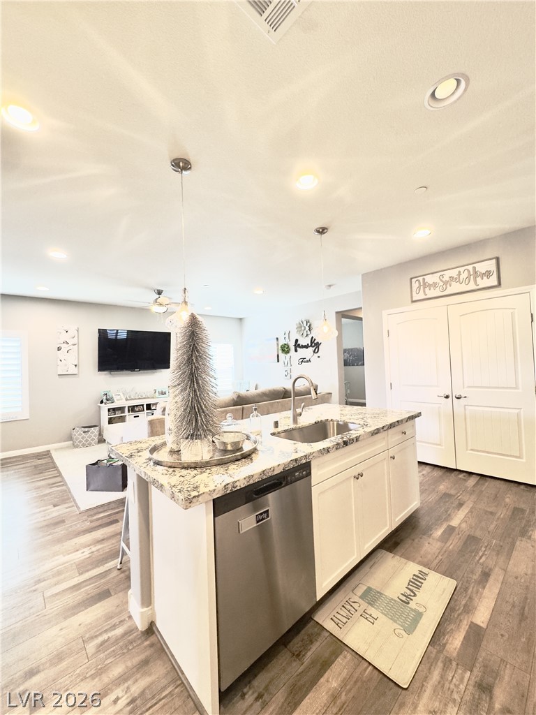 78 Summer Rhapsody Avenue Henderson, NV 89015 - Photo 30 of 31 Kitchen featuring light stone counters, open floor plan, an island with sink, white cabinetry, and stainless steel dishwasher