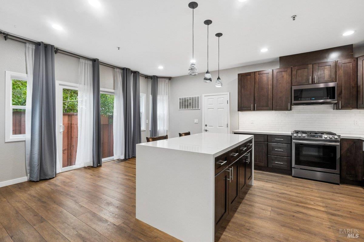 4 Courtney Lane Mill Valley, CA 94941 - Photo 5 of 14 a kitchen with stainless steel appliances granite countertop a stove top oven a sink dishwasher a refrigerator and a oven with wooden floor