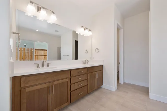 a spacious bathroom with a double vanity sink mirror and