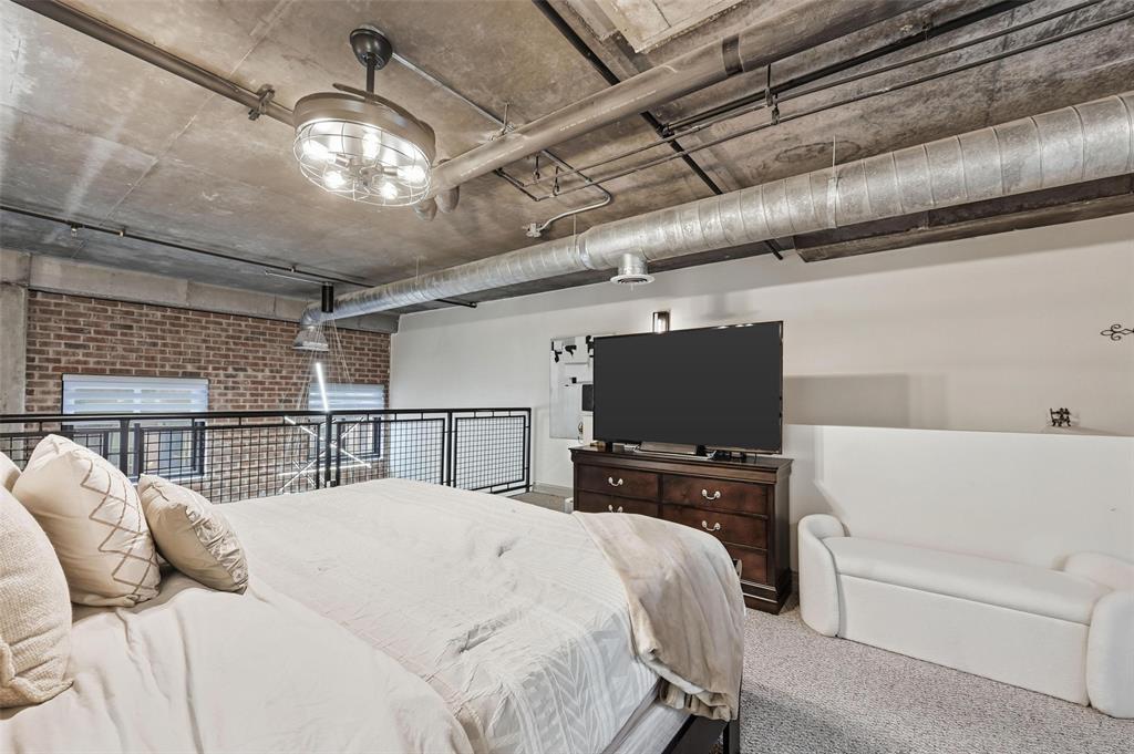 3110 Thomas Avenue, Unit 105 Dallas, TX 75204 - Photo 21 of 37 a bedroom with a bed and a flat screen tv