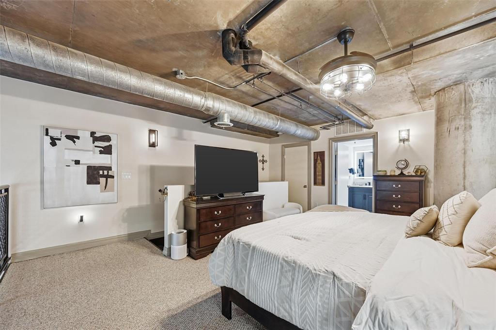 3110 Thomas Avenue, Unit 105 Dallas, TX 75204 - Photo 22 of 37 a bedroom with a bed and a flat tv screen on the dresser