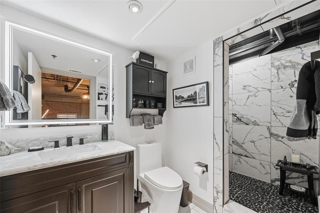 3110 Thomas Avenue, Unit 105 Dallas, TX 75204 - Photo 23 of 37 a bathroom with a granite countertop sink toilet and shower