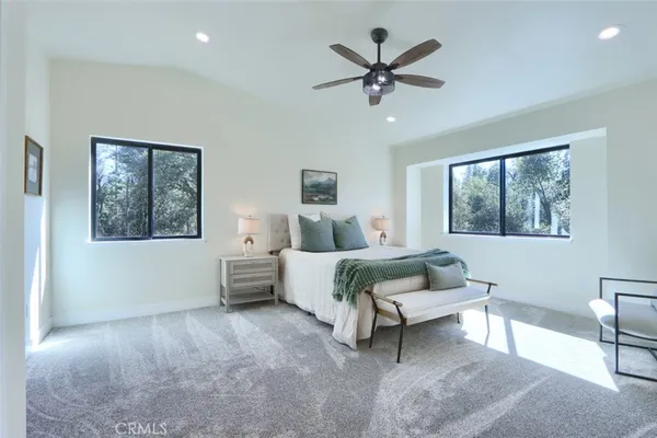 a bedroom with a large bed chandelier and a window
