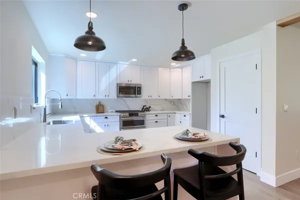 a kitchen with stainless steel appliances a dining table and chairs