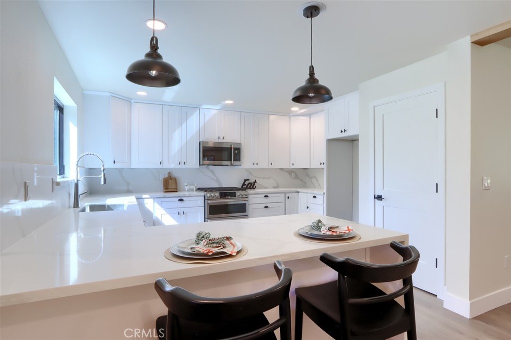 3181 B Triangle Park Road Mariposa, CA 95338 - Photo 7 of 44 a kitchen with stainless steel appliances a dining table and chairs