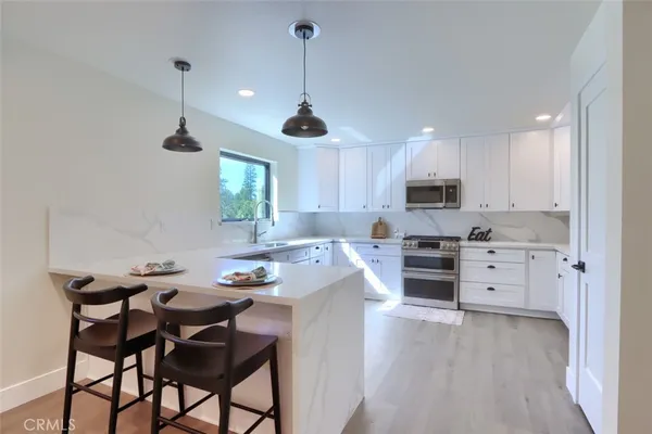 a kitchen with kitchen island granite countertop a sink cabinets and wooden floor