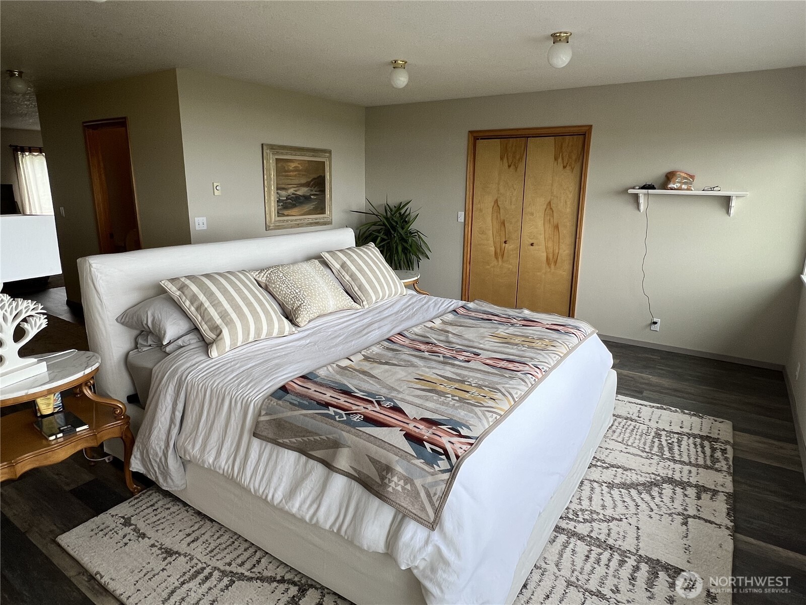 240 Stringtown Road Ilwaco, WA 98624 - Photo 10 of 39 a bedroom with a bed and wooden floor