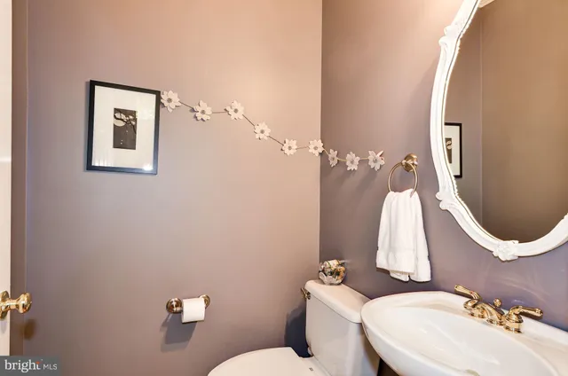 a bathroom with a sink vanity mirror and toilet