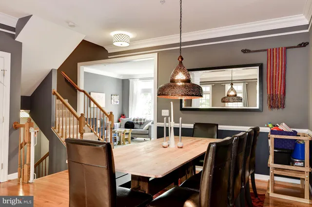 a view of a dining room and livingroom with furniture wooden floor a chandelier