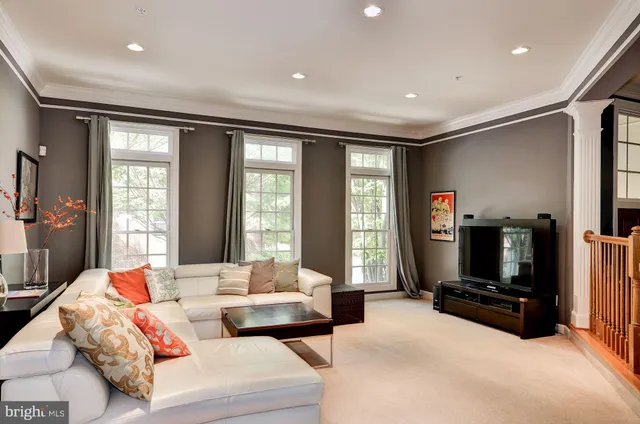 a living room with furniture a flat screen tv and a large window
