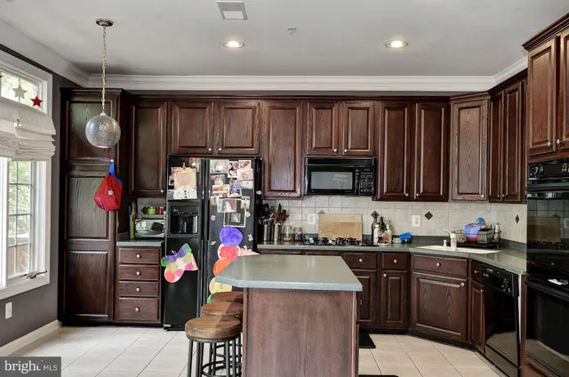 a kitchen that has a lot of cabinets and stainless steel appliances