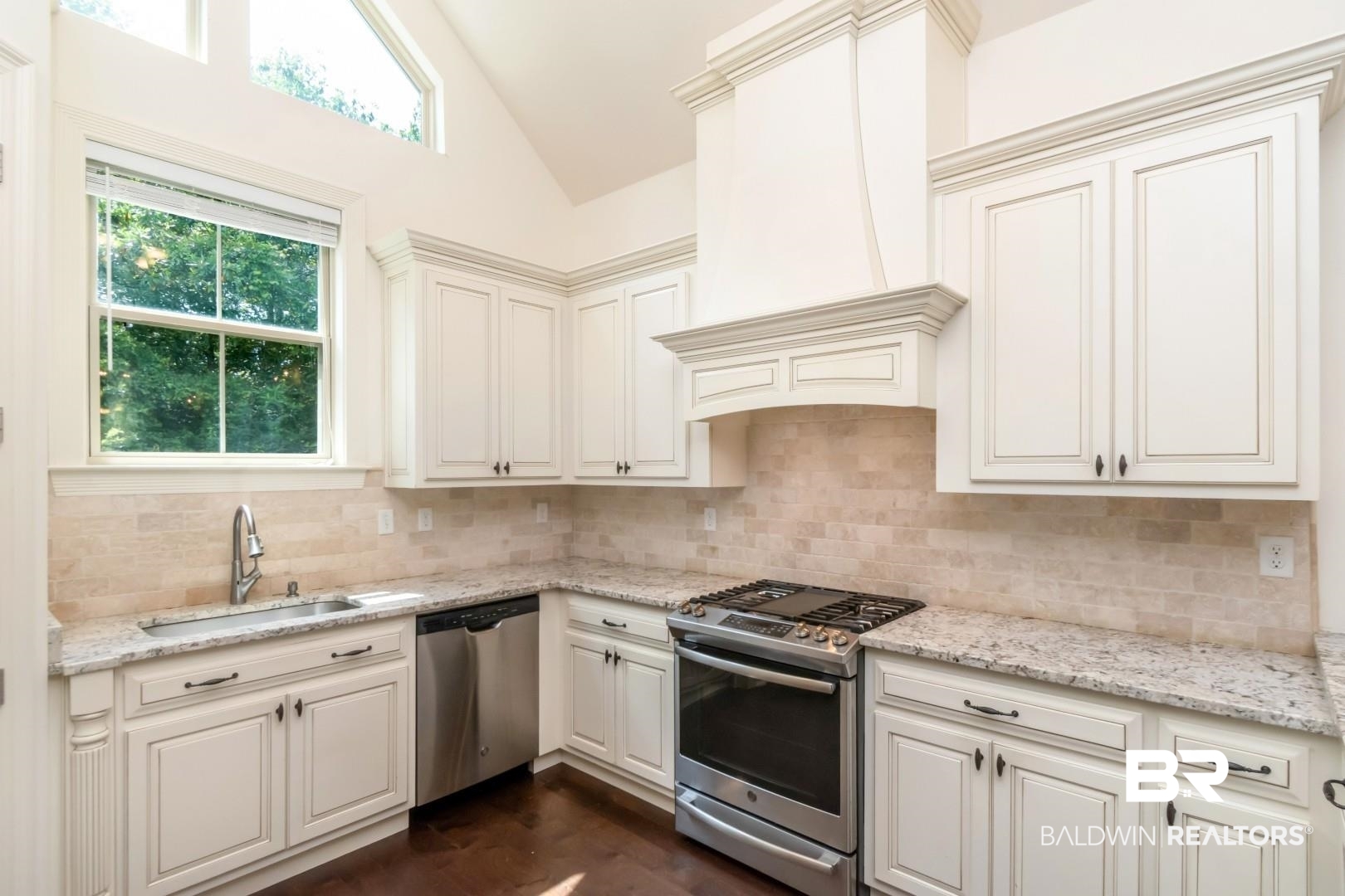 3528 Rue Royal Mobile, AL 36693 - Photo 12 of 53 Kitchen featuring white cabinetry, light-toned stone countertops, stainless steel appliances, a tile backsplash, and wood-finish flooring