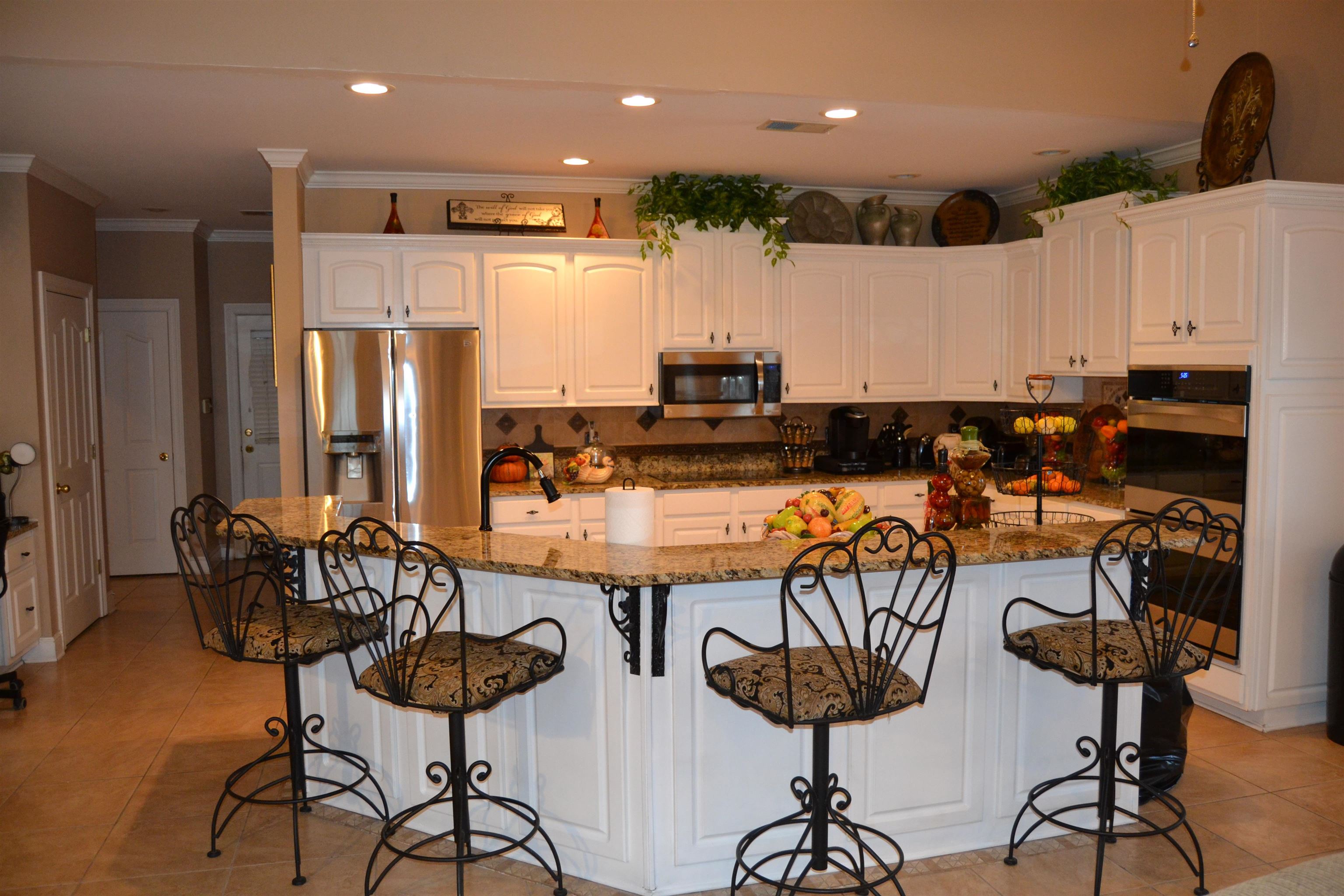 1364 Winoka Road Collierville, TN 38017 - Photo 8 of 25 a kitchen with stainless steel appliances kitchen island granite countertop a table and chairs in it