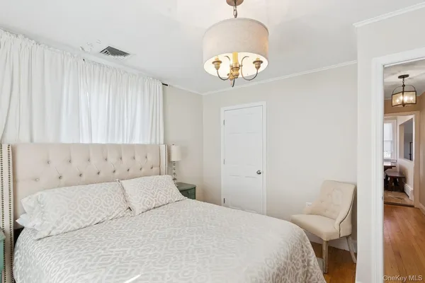 a bedroom with a bed and a chandelier