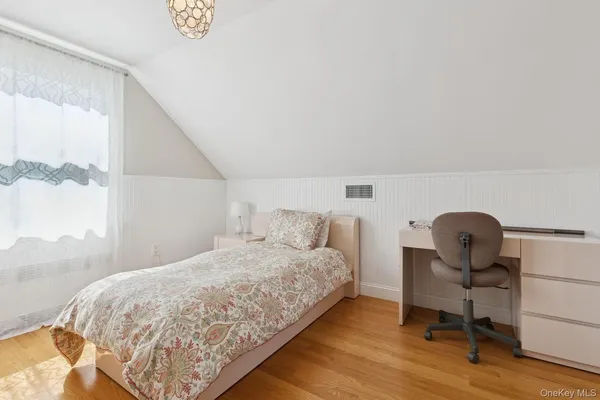 a bedroom with a bed and a desk next to a window