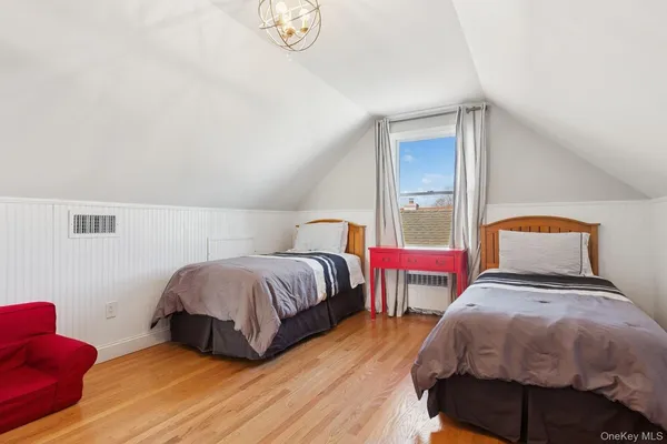 a bedroom with two beds and a lamp