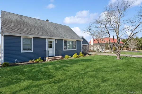 a view of a house with a yard and sitting area