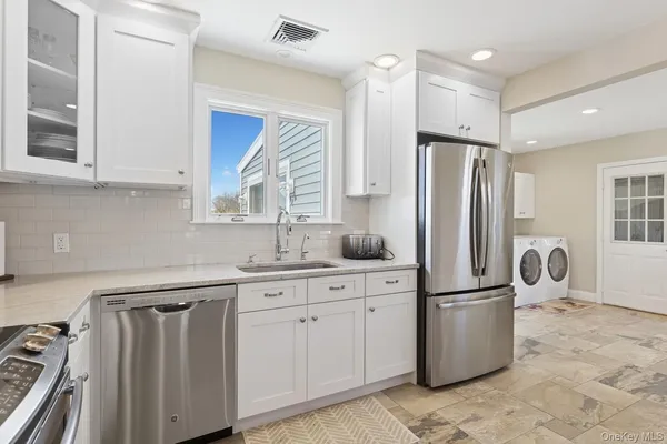 a kitchen with a refrigerator sink and cabinets