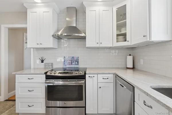 a kitchen with white cabinets and appliances