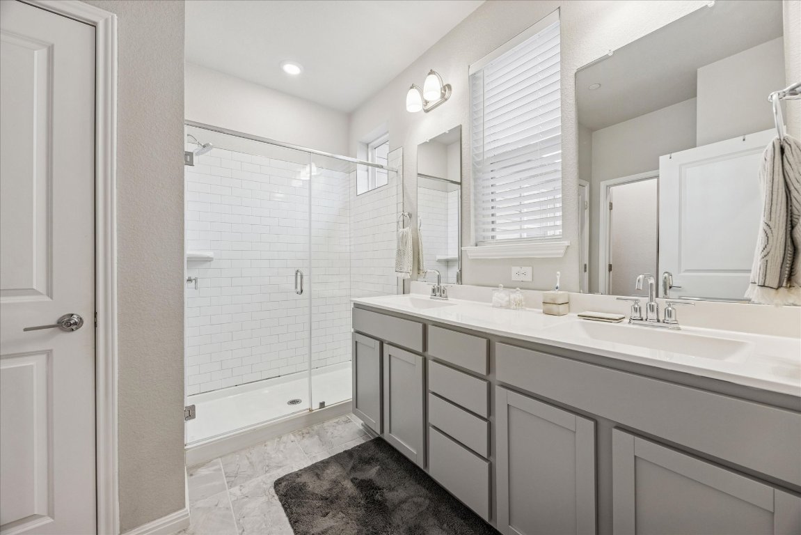 9015 Cattle Baron Path, Unit 1002 Austin, TX 78747 - Photo 11 of 21 a bathroom with double sink and a mirror