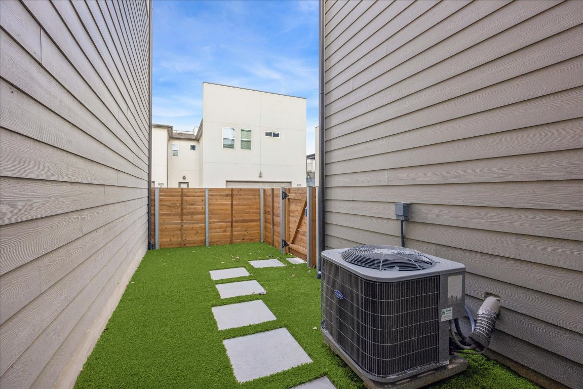 9015 Cattle Baron Path, Unit 1002 Austin, TX 78747 - Photo 16 of 21 a view of a backyard with plants and brick wall