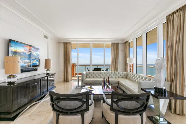 a living room with furniture a large window and a flat screen tv