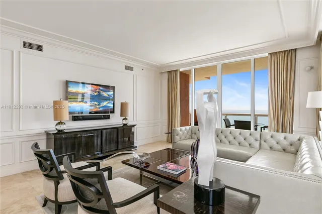 a living room with furniture a flat screen tv and a window