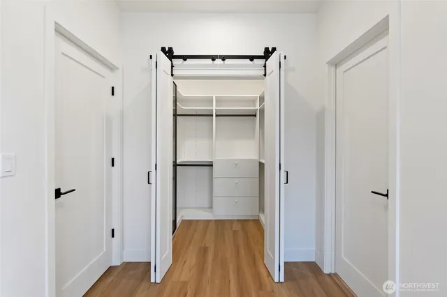 a view of walk in closet with wooden floor