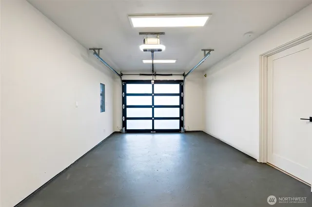 an empty room with windows and ceiling fan