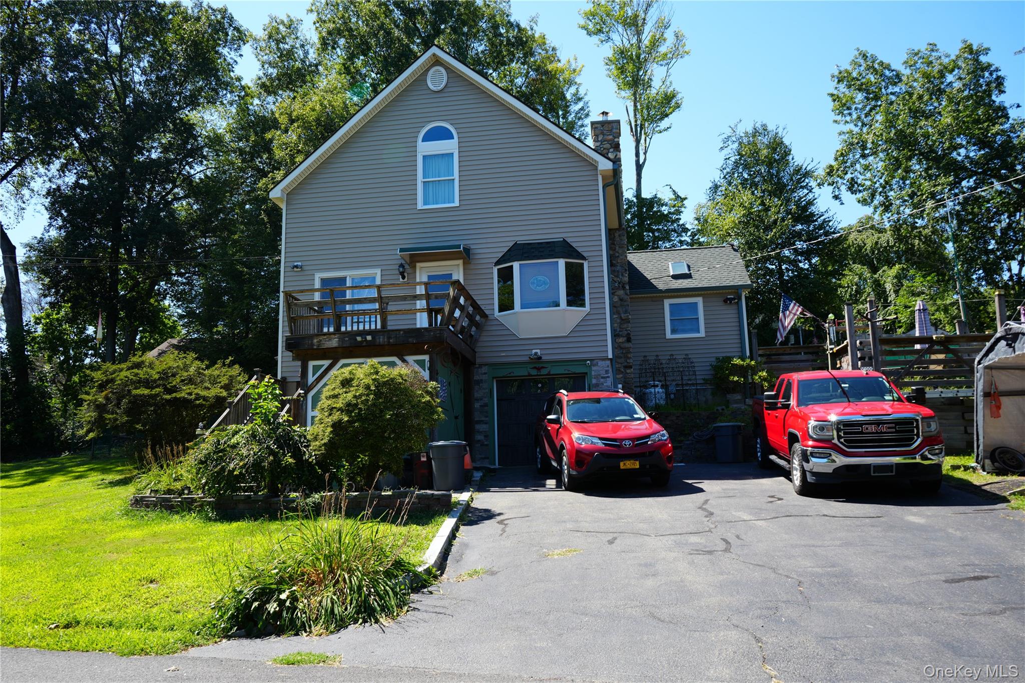 a front view of a house with a garden and parking