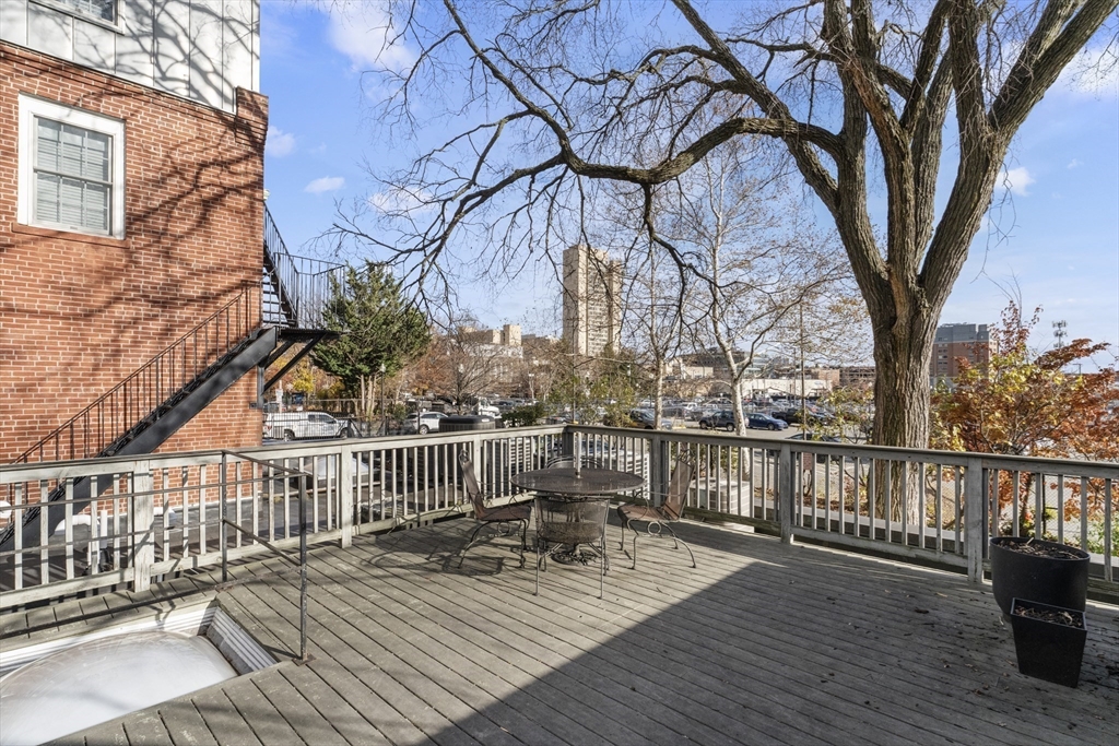 8 Newcomb Street, Unit 4 Boston, MA 02118 - Photo 14 of 16 a view of a deck with wooden floor and fence with a barbeque