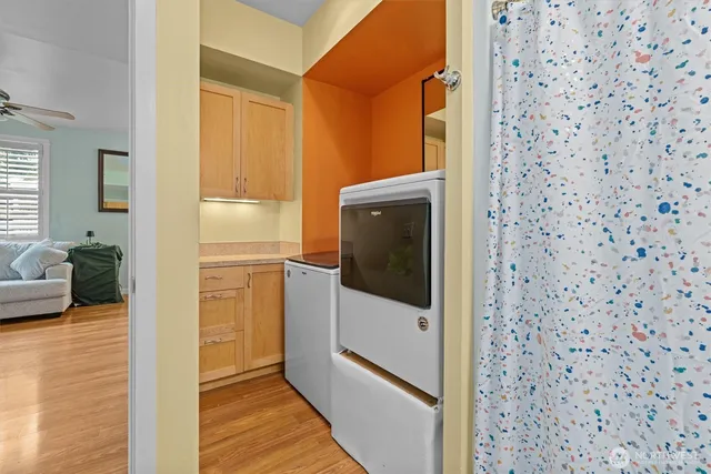 a view of a hallway with wooden floor and living room