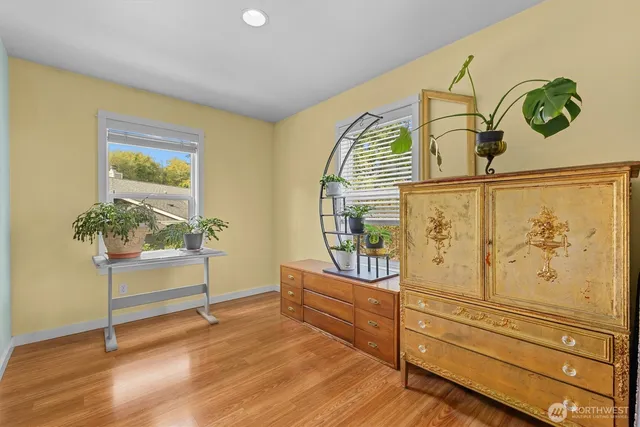 a view of a hallway with wooden floor and furniture