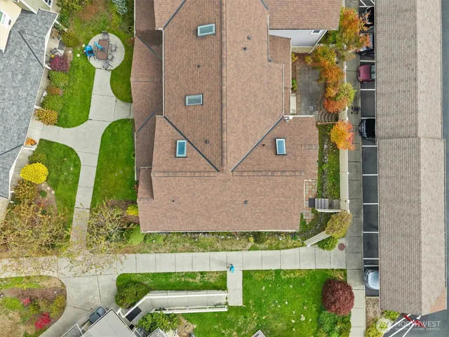 front view of a white house with a yard and potted plants