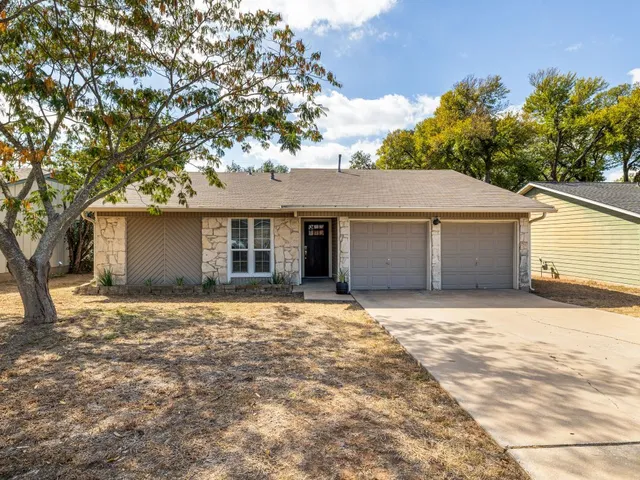 a front view of a house with a garden and yard