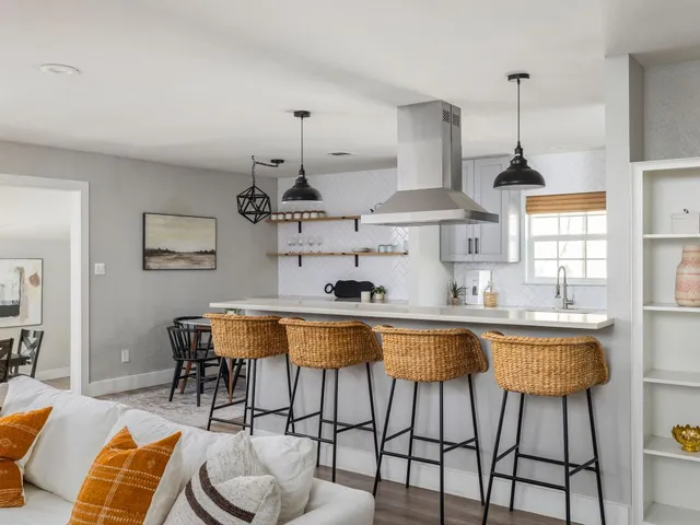 a kitchen with stainless steel appliances a dining table chairs sink and cabinets