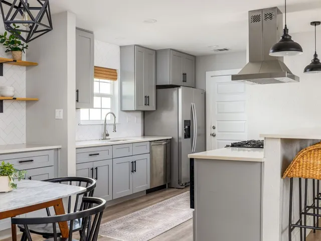 a kitchen with stainless steel appliances a stove a sink and a refrigerator